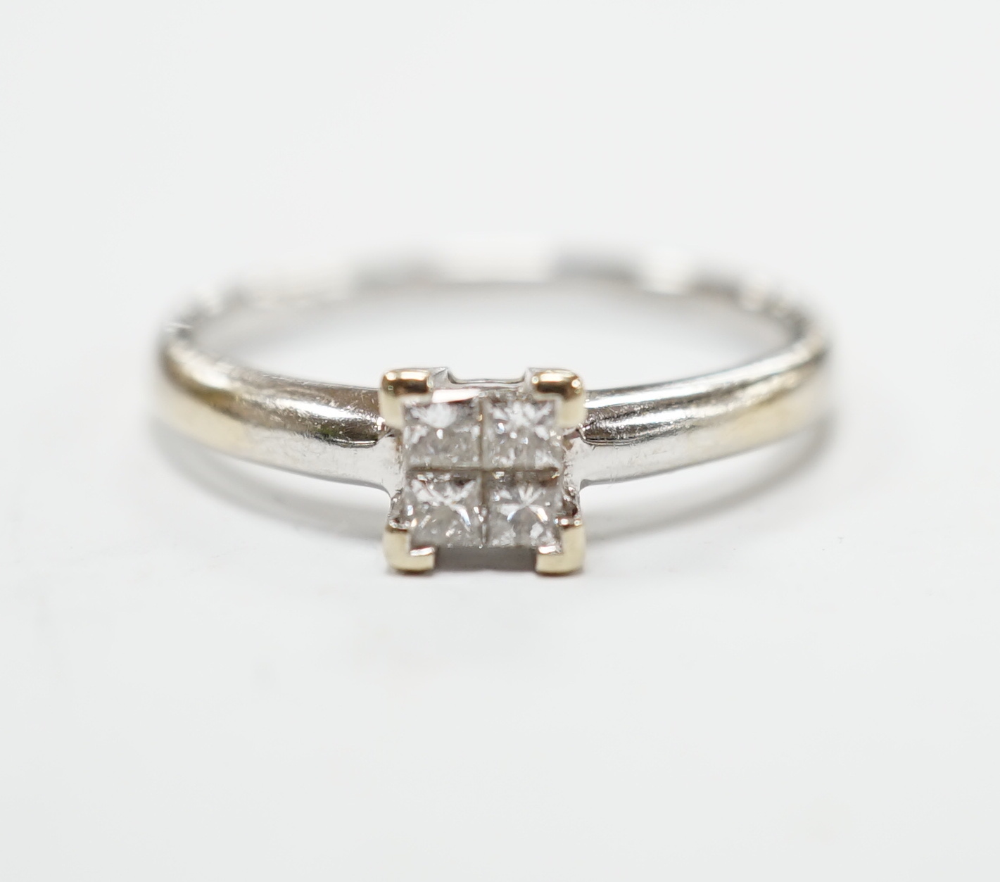 A modern 18ct white gold and four stone diamond set square cluster ring, size P/Q, gross weight 3.2 grams.
